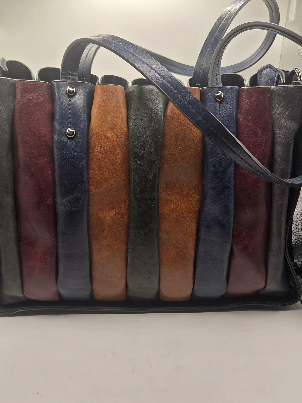Shopper tote bag made of narrow strips of black, brown, and red leather
